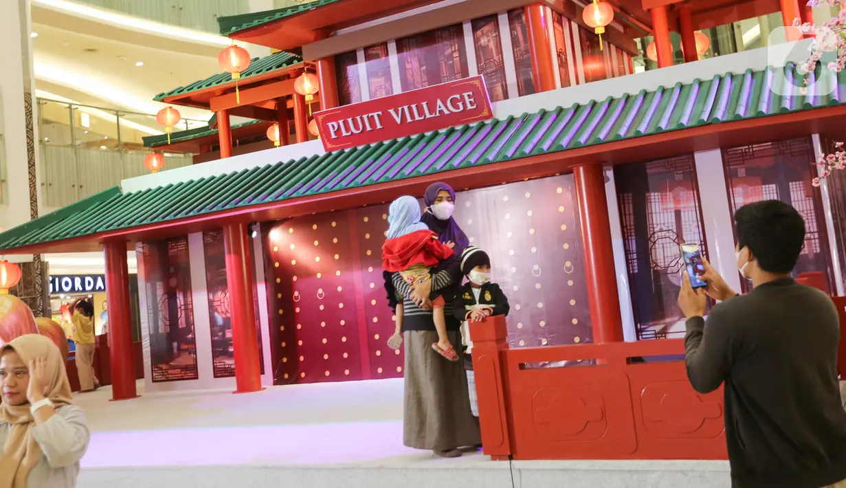 Pengunjung saat foto berlatar belakang rumah Tiongkok di Pluit Village Jakarta Utara (23/02/2022). Pluit Village juga menampilkan rangkaian kegiatan seperti, barongsai tonggak, akrobatik barongsai, liong dance, dan beberapa kompetisi mandarin sing baby kids barongsai. (Liputan6.com/Fery Pradolo)