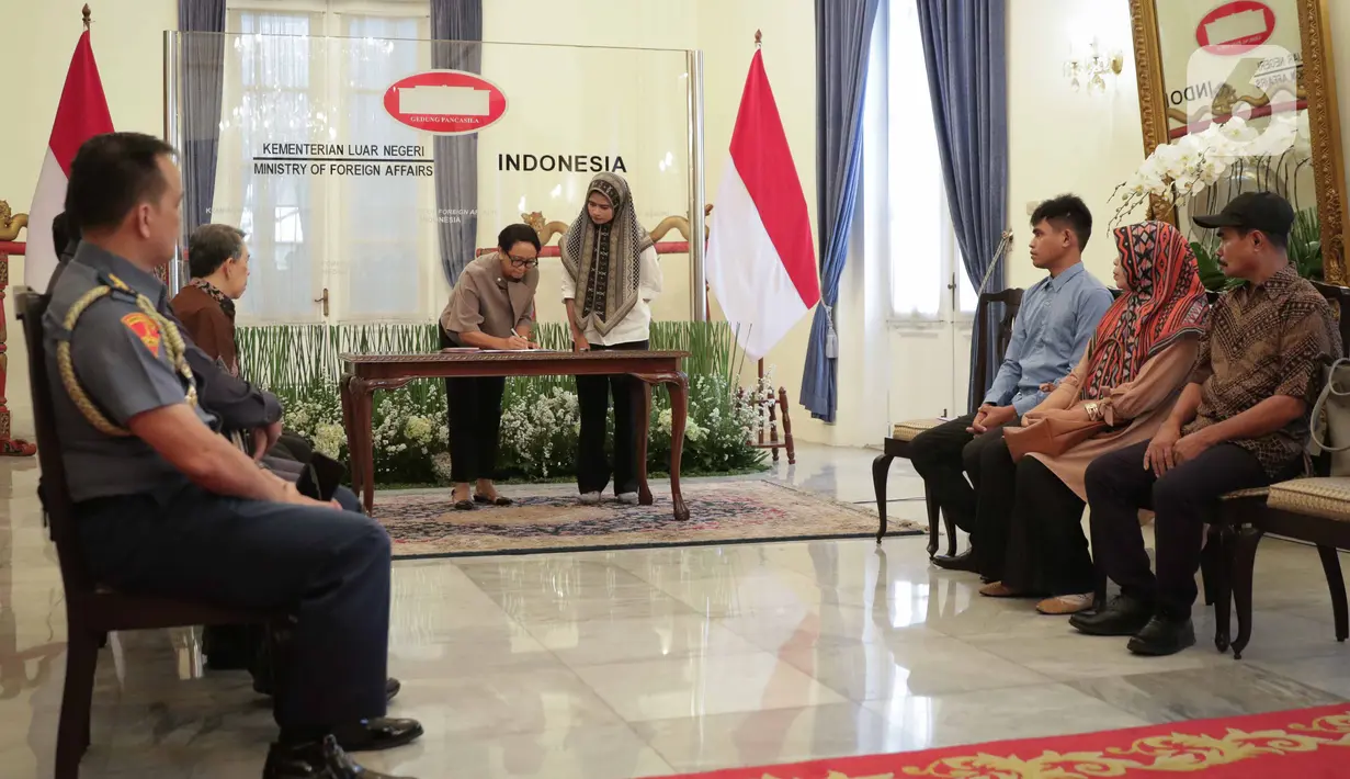 Menlu Retno Marsudi menandatangani dokumen saat menyerahkan Muhammad Farhan, WNI yang disandera kelompok Abu Sayyaf ke keluarga di Kemenlu, Jakarta, Kamis (23/1/2020). (Liputan6.com/Faizal Fanani)