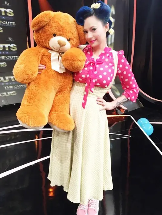 Tampil girly, sontek gaya Claudia satu ini yang memadukan overall plaid skirt dengan blouse polkadot warna pink. (Instagram/miss_adinda_mae).