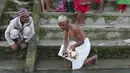 Seorang pendeta Nepal melakukan ritual untuk seorang penyembah selama festival Kuse Aunsi di Kathmandu, (30/8/2019). Kuse Aunsi lebih dikenal dengan sebutan Gokarna Aunsi adalah perayaan yang terjadi pada akhir Agustus, tergantung pada kalender lunar. (AP Photo/Niranjan Shrestha)