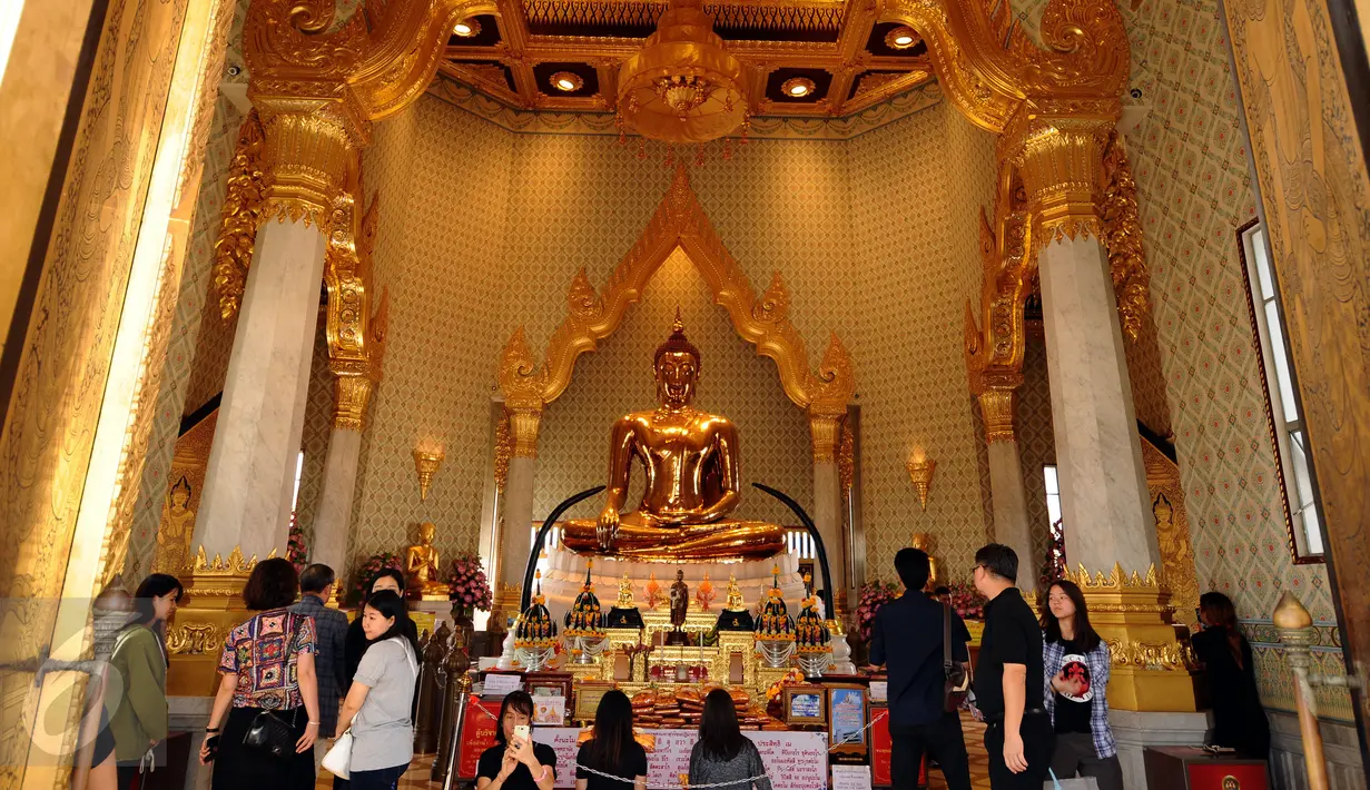 Pengunjung berdoa di depan Golden Budha di kota Bangkok, Thailand, Sabtu (17/12). Salah satu biksu yang ada di kuil tersebut memprediksi hasil laga final kedua Piala AFF 2016 antara Thailand melawan Indonesia. (Liputan6.com/Helmi Fithriansyah)