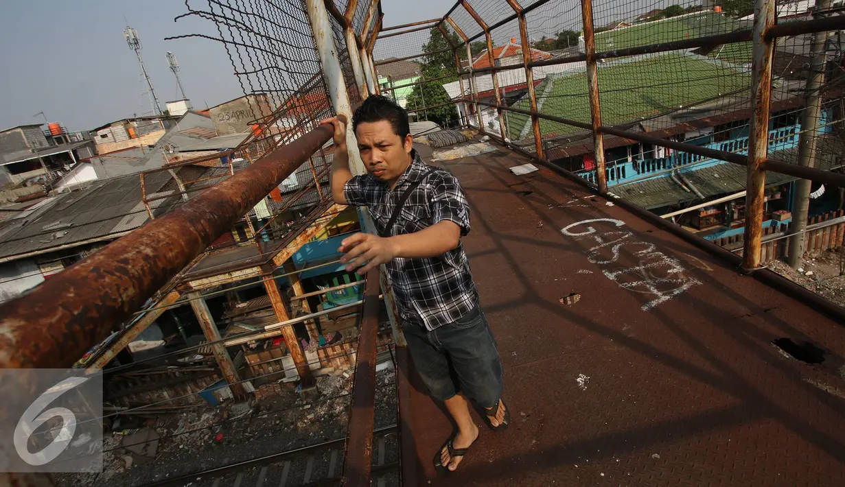 Pejalan kaki memegang tiang jembatan saat melintas di kawasan Tebet, Jakarta, Kamis (5/11). Kondisi jembatan yang sudah berkarat dan berlubang tersebut membahayakan pejalan kaki terutama saat malam hari. (Liputan6.com/Immanuel Antonius)