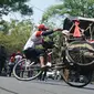 Salah seorang peserta lomba balap becak melakukan atraksi mengangkat roda. (Liputan6.com/Huyogo Simbolon)