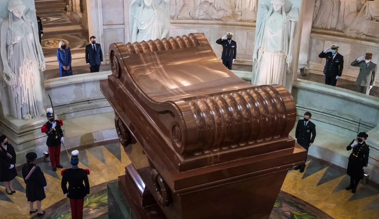 Presiden Prancis Emmanuel Macron dan istrinya Brigitte Macron berdiri di depan makam Kaisar Prancis Napoleon (1769-1821) saat upacara peringatan 200 tahun kematiannya di Chapelle Saint-Jerome, Invalides, Paris, Prancis, Rabu (5/5/2021). (Christophe PETIT TESSON/POOL/AFP)