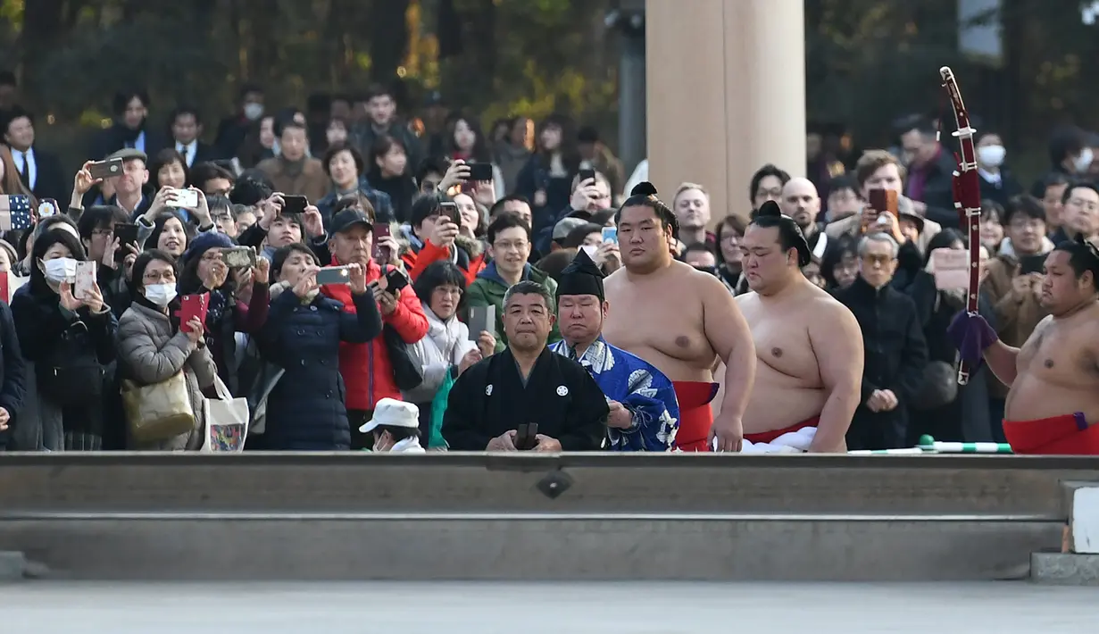 Juara Grand Sumo, Kisenosato (kedua depan) memasuki lapangan untuk melakukan upacara mengentakkan kaki menyambut tahun baru di Kuil Meiji, Tokyo, 8 Januari 2019. Ritual penyambutan tahun baru itu melibatkan tiga juara pegulat sumo (Toshifumi KITAMURA/AFP)