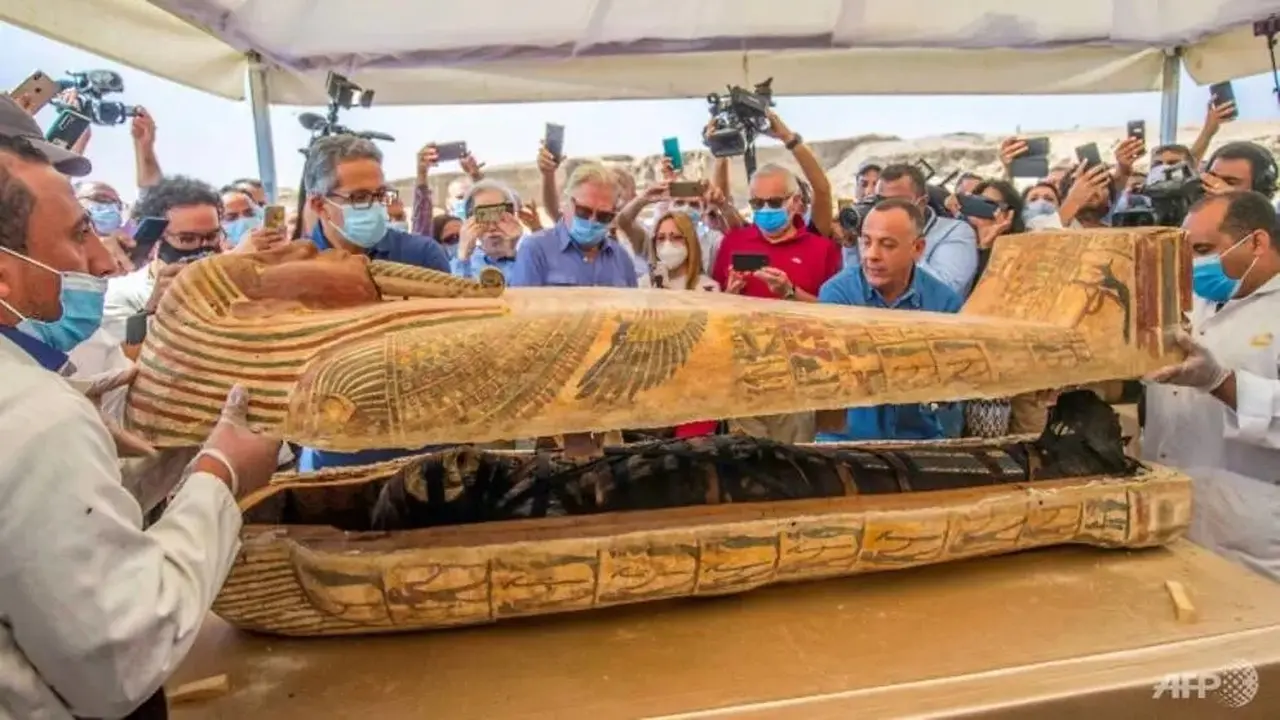 Menteri pariwisata dan barang antik Mesir, Khaled al-Anani (kiri), dan Mostafa Waziri (kanan), sekretaris jenderal Dewan Tertinggi Purbakala, membuka sarkofagus yang digali di pekuburan Saqqara.