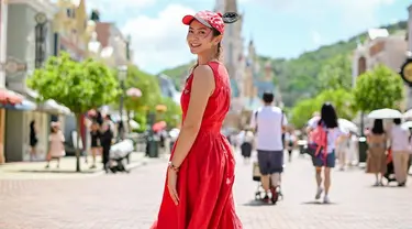 Dalam momen liburan bersama Podkesmas itu, Tyara Renata tampil menawan dengan sleveeless dress merah menyala. Berjalan menyusuri berbagai wahana di Disneyland Hong Kong, wanita 36 tahun itu tampil awet muda saat mengenakan tambahan aksesori topi khas Mickey Mouse. (Liputan6.com/IG/@tyararenata)
