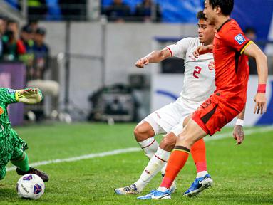 Pemain Timnas Indonesia, Mees Hilgers (tengah) berusaha mencetak gol ke gawang China yang dijaga oleh Wang Dalei saat laga lanjutan putaran ketiga Grup C Kualifikasi Piala Dunia 2026 di Qingdao Youth Stadium, Qingdao, China, Selasa (15/10/2024). (AFP)