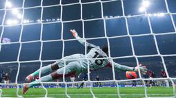 Kiper AC Milan, Mike Maignan, berhasil menggagalkan tendangan penalti pemain Inter Milan, Hakan Calhanoglu, pada laga Italia di Stadion Giuseppe Meazza, Senin (2411/2025). (AP Photo/Antonio Calanni)