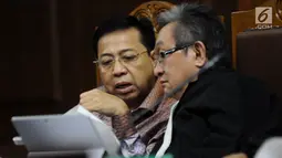 Terdakwa dugaan korupsi proyek e-KTP Setya Novanto (kiri) berbincang dengan kuasa hukumnya saat mengikuti sidang lanjutan di Pengadilan Tipikor, Jakarta, Senin (15/1). Sidang bergaendakan mendengar keterangan saksi. (Liputan6.com/Helmi Fithriansyah)