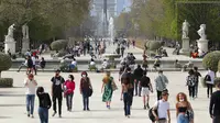 Orang-orang memakai masker wajah saat mereka berjalan di jalur taman Tuileries, Paris, Prancis, Kamis (1/4/2021). Prancis bersiap melakukan lockdown setelah pemerintah menemukan adanya lonjakan kasus COVID-19. (AP Photo/Thibault Camus)