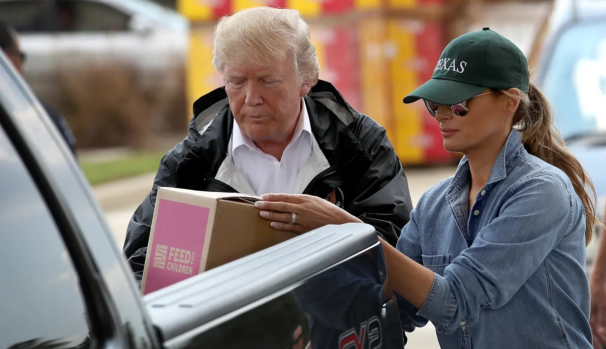 Presiden AS Donald Trump dan Ibu Negara Melania Trump membawa barang untuk disumbangkan kepada korban Badai Harvey saat berkunjung ke First Church, Pearland, Texas (2/9). (Win McNamee/Getty Images/AFP)