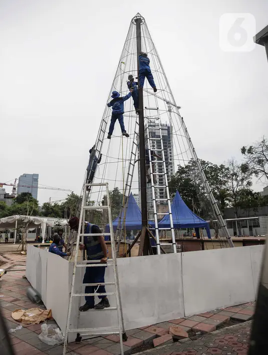 Pekerja memasang rangka pohon natal yang terbuat dari sampah botol plastik di Thamrin 10, Jakarta, Kamis (19/12/2019). Pemprov DKI sedang membangun dua pohon Natal setinggi 10 meter di Lapangan Banteng dan Thamrin menjelang perayaan Natal pada 25 Desember 2019 mendatang. (Liputan6.com/Faizal Fanani)