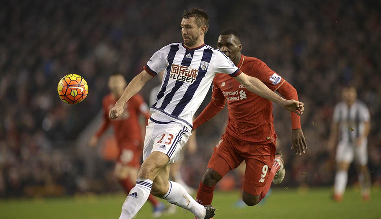 Bek West Bromwich, Gareth McAuley, berusaha menghindari kejaran striker Liverpool, Christian Benteke, pada laga Liga Premier Inggris di Stadion Anfiled, Inggris, Minggu (13/12/2015). kedua tim bermain imbang 2-2. (AFP/Oli Scarff)