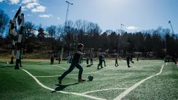 Keseruan anak-anak bermain di lapangan Puckelboll di Skarholmen, Stockholm, Swedia, 11 April 2016.  Lapangan Puckelboll adalah lapangan sepak bola buatan yang bergelombang dan merupakan karya seni dari Johan Storm. (Jonathan NACKSTRAND/AFP) 