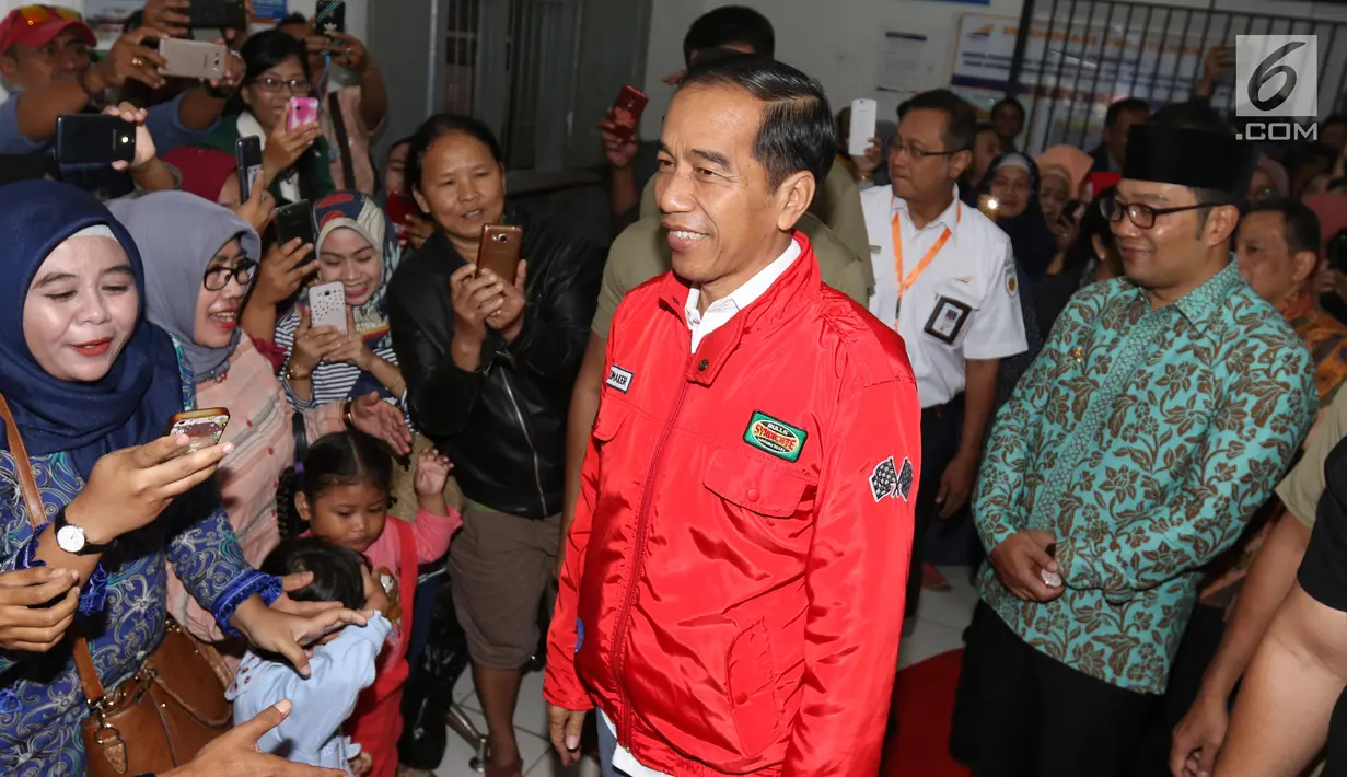 Presiden Joko Widodo menyapa para calon penumpang saat kunjungan kerja di Stasiun Cibatu, Garut, Jumat (18/1). Kedatangan Jokowi yang didampingi Ibu Negara Iriana  itu untuk meninjau reaktivasi jalur kereta api Cibatu-Garut. (Liputan6.com/Angga Yuniar)