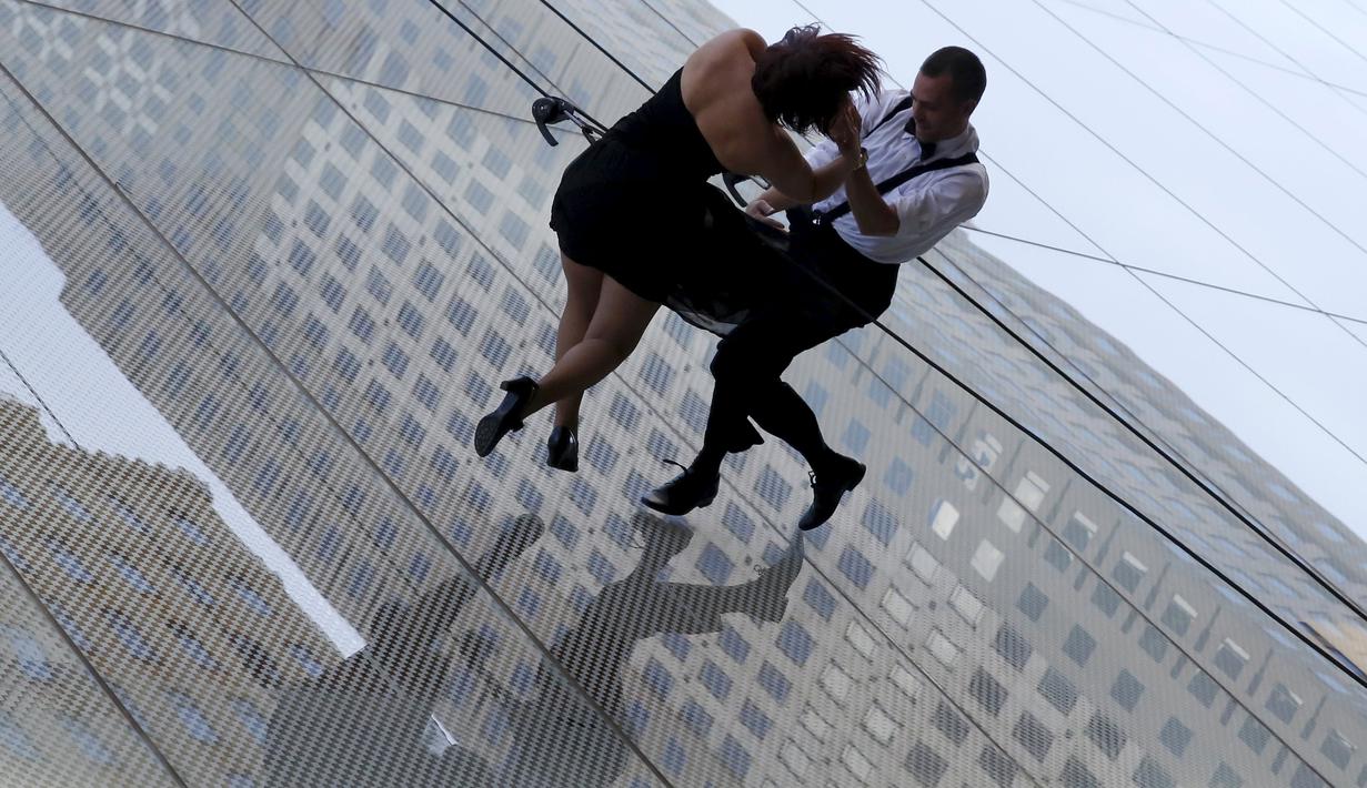Penari beraksi melakukan tarian di dinding bangunan gedung di Manhattan borough New York (19/4). Aksi nekat ini merupakan bagian dari pembukaan toko "Hublot"di Fifth Avenue, Manhattan. (REUTERS/Andrew Kelly)