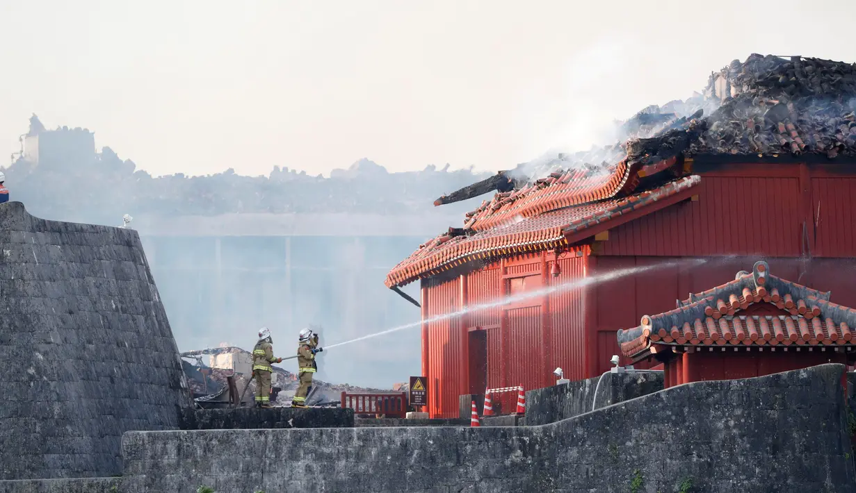 Petugas pemadam kebakaran berusaha memadamkan api yang membakar Kastil Shuri di Okinawa, Jepang selatan, Kamis (31/10/2019). Kastil ini pernah hancur beberapa kali akibat perang, salah satunya akibat Perang Okinawa tahun 1945, dan telah dibangun kembali. (Jun Hirata/Kyodo News via AP)