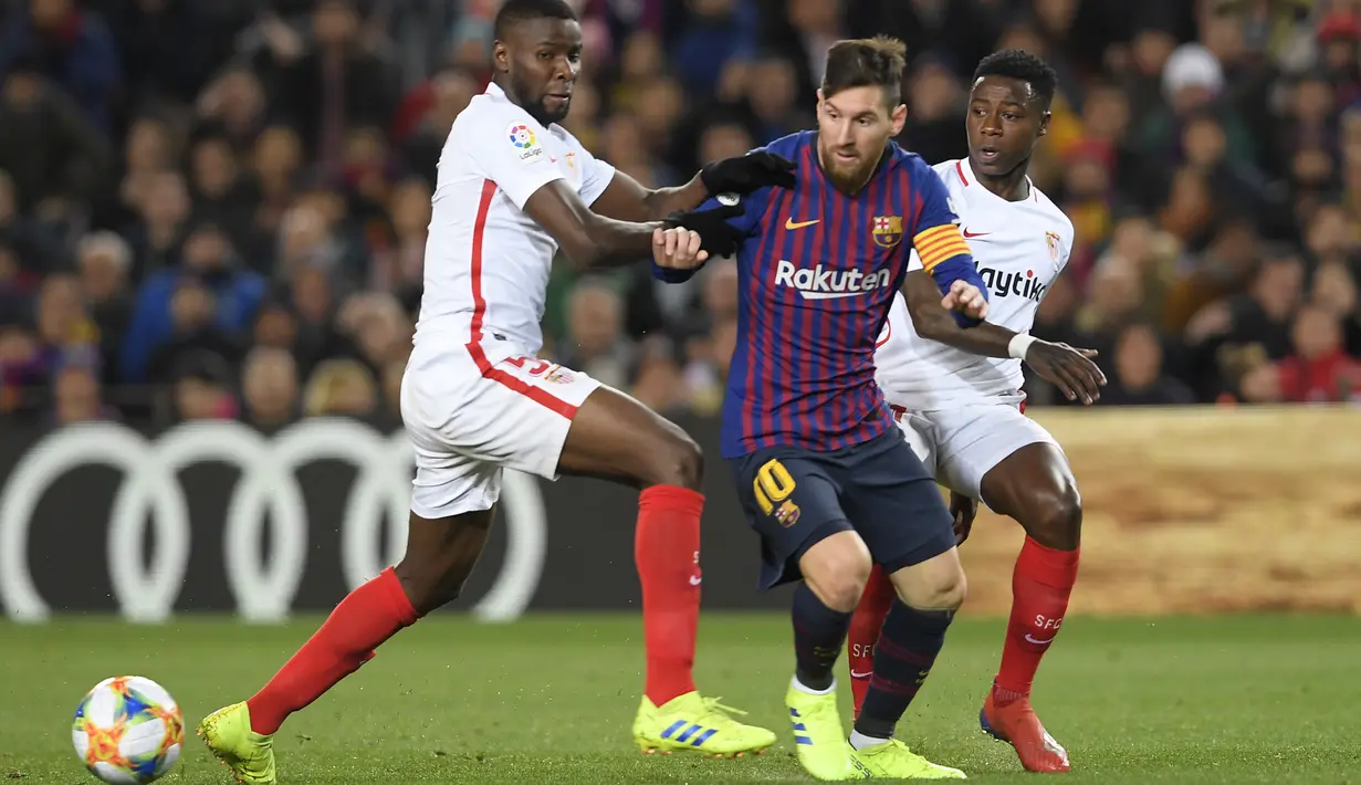 Aksi bintang Barcelona, Lionel Messi melewati dua pemain Sevilla pada leg kedua Copa Del Rey yang berlangsung di stadion Nou Camp, Barcelona, Kamis (31/1). Barcelona menang 6-1 atas Sevilla. (AFP/Luis Gene)