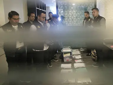 Satgas Antimafia Bola Polri menunjukan barang bukti hasil penggeledahan dari kantor PSSI di Fx  Tower, Jakarta, Rabu (30/1). Dokumen-dokumen tersebut berkaitan dengan persepakbolaan dan anggaran tahun 2017 dan 2018. (Liputan6.com/Faizal Fanani)
