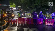 Polisi berjaga saat penyekatan jalan di kawasan Pasar Baru, Jakarta, Kamis (31/12/2020). Polda Metro Jaya menutup sejumlah ruas jalan selama Car Free Night dan Crowd Free Night pada malam Tahun Baru 2021 untuk mencegah penyebaran COVID-19. (Liputan6.com/Faizal Fanani)