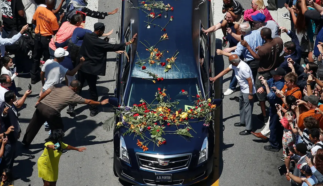 Sejumlah penggemar mengulurkan tangan untuk menyentuh mobil jenazah yang membawa jasad mantan petinju dunia, Muhammad Ali saat akan dimakamkan di Louisville, Kentucky, AS, 10 Juni 2016. (REUTERS/Adrees Latif )