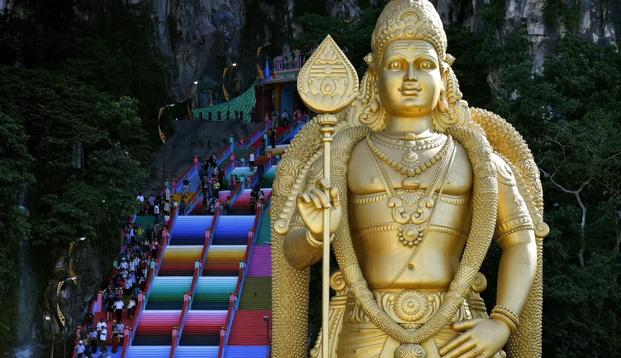 Pengunjung menaiki tangga 272 langkah yang baru dicat, jalan menuju kuil Batu Caves di Kuala Lumpur, Malaysia, 30 Agustus 2018. Hasil renovasi tersebut dianggap merusak tatanan budaya dan kelestarian objek wisata bersejarah itu. (AFP/Manan VATSYAYANA)