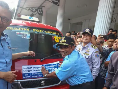 PLT Gubernur DKI Jakarta Soni Sumarsono (kanan) menempelkan stiker integrasi Transjakarta-Koperasi Wahana Kalpika (KWK) saat peresmian di Halaman Balaikota, Jakarta, Senin (3/4). (Liputan6.com/Faizal Fanani)