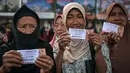 Jumlah ini naik 100 persen dibandingkan tahun lalu yang tercatat sekitar 16 ribu penerima. Guna menghindari penumpukan warga, penyaluran dilakukan secara bertahap selama 12 hari. Tampak dalam foto, warga memperlihatkan uang hasil pembagian zakat di Masjid Cheng Hoo, Surabaya, Jawa Timur pada Rabu 4 Maret 2026. (JUNI KRISWANTO/AFP)