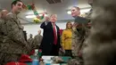 Presiden Donald Trump dan ibu negara Melania Trump menyapa pasukan militer Amerika dalam kunjungan kejutan di Pangkalan Udara al Asad, Irak, Rabu (26/12). Trump mengunjungi Irak didampingi sejumlah jajarannya selama kurang lebih 3 jam. (AP/Andrew Harnik)