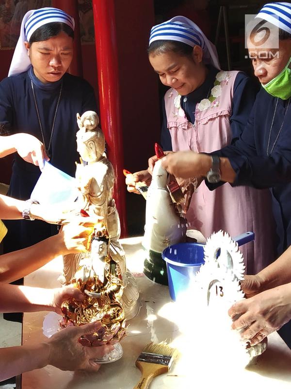 Suster Katolik dan pengurus vihara membersihkan patung dewa dewi di Vihara Kwan In Thang, Pondok Cabe, Tangerang Selatan, Rabu (30/1). Dalam pembersihan itu melibatkan umat agama lain sebagai bentuk toleransi kerukunan beragama. (Merdeka.com/Arie Basuki)