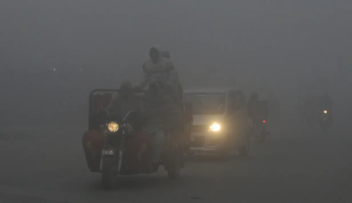 Sejumlah kendaraan melintas saat kabut asap tebal menyelimuti Lahore, Pakistan (3/1). Polusi udara telah menyebar akibat asap kendaraan, situs bangunan dan petani yang membakar tanaman di daerah di luar ibukota India. (AFP Photo/Arif Ali)