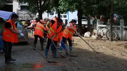 Regu penyelamat membersihkan endapan lumpur di jalanan Kota Bifeng, Provinsi Guizhou, China, Sabtu (13/6/2020). Banjir yang dipicu oleh hujan telah berdampak pada kehidupan 700.000 orang di Provinsi Guizhou. (Xinhua/Liu Xu)