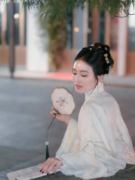 Mengenakan busana bernuansa putih dengan aksen bunga-bunga, penampilan Wilo dengan gaya rambut khas asal China ini terlihat semakin menawan. Tidak sedikit yang menyebut bahwa Wilo sudah cocok untuk bermain drama kolosan China. (Liputan6.com/IG/@natashawilona12)
