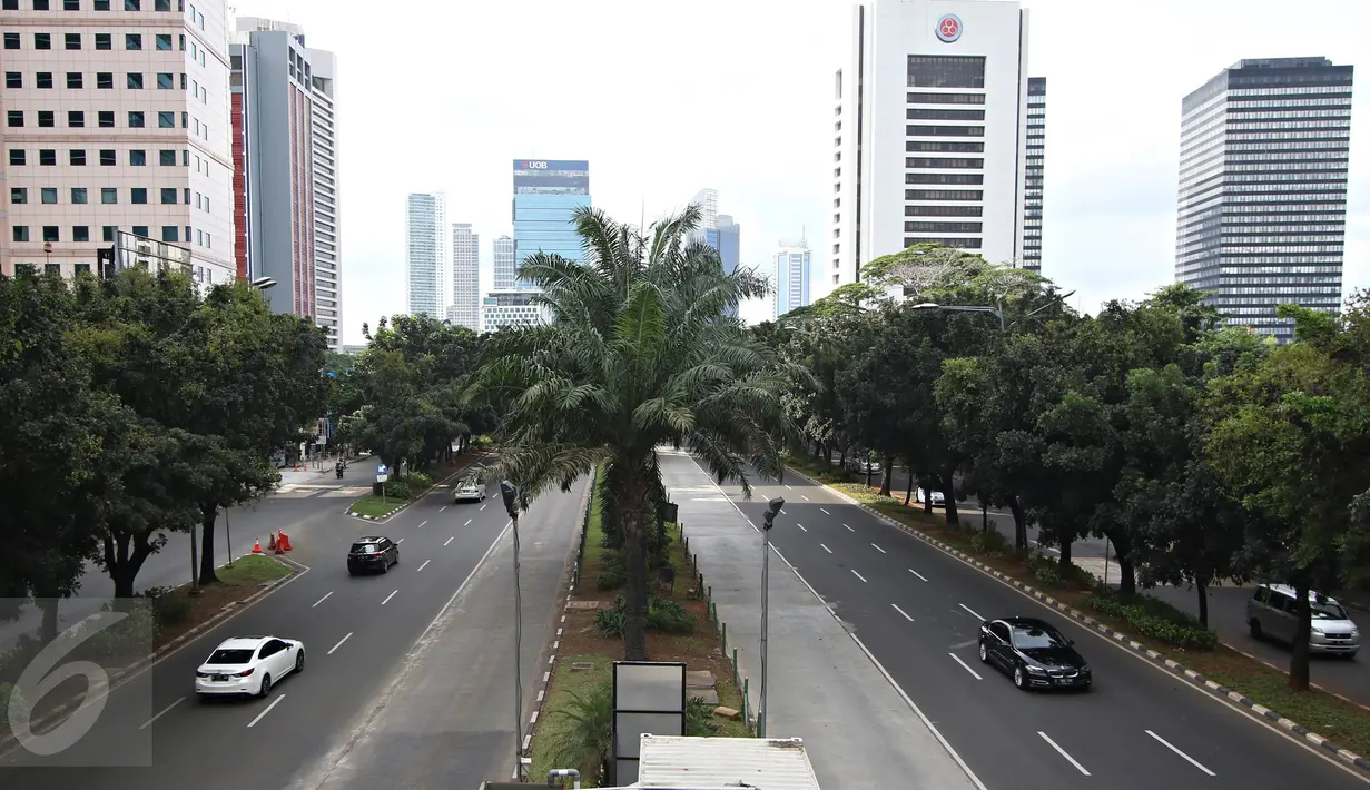 Kendaraan melintasi Jalan Sudirman yang lengang di Jakarta, Minggu (1/5). Hal ini diakibatkan Hari Buruh 2016 kali ini jatuh pada hari Minggu dan berpusat di Stadion GBK. (Liputan6.com/Immanuel Antonius)