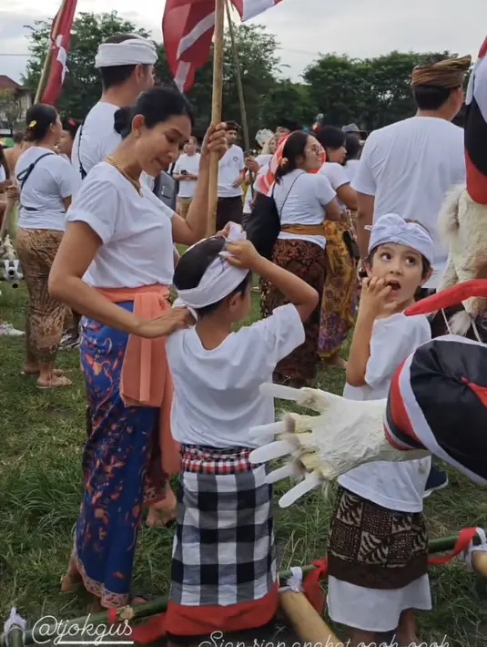 Atasan tersebut dipadukan kain batik warna biru sebagai bawahannya serta kain orange yang diikat di pinggangnya. Tampak ia pun mengenakan kalung dan anting-anting. [@happysalma]