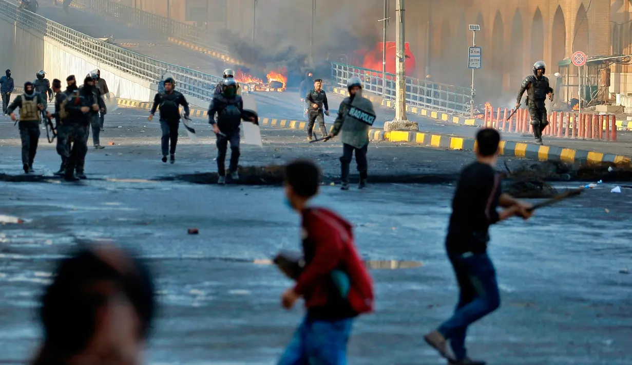 Pasukan keamanan berusaha membubarkan demonstran antipemerintah saat bentrokan di Najaf, Irak, Kamis (28/11/2019). Kerusuhan di Ibu Kota dan wilayah selatan Irak terus meningkat setelah pembakaran gedung Konsulat Iran. (AP Photo/Anmar Khalil)