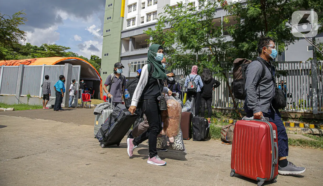 Warga negara Indonesia (WNI) membawa koper mereka usai menjalani isolasi di RSDC Wisma Atlet Pademangan, Jakarta, Selasa (15/6/2021). Pemerintah mewajibkan WNI yang baru tiba di Indonesia untuk melakukan isolasi selama lima hari guna menghindari penularan COVID-19. (Liputan6.com/Faizal Fanani)