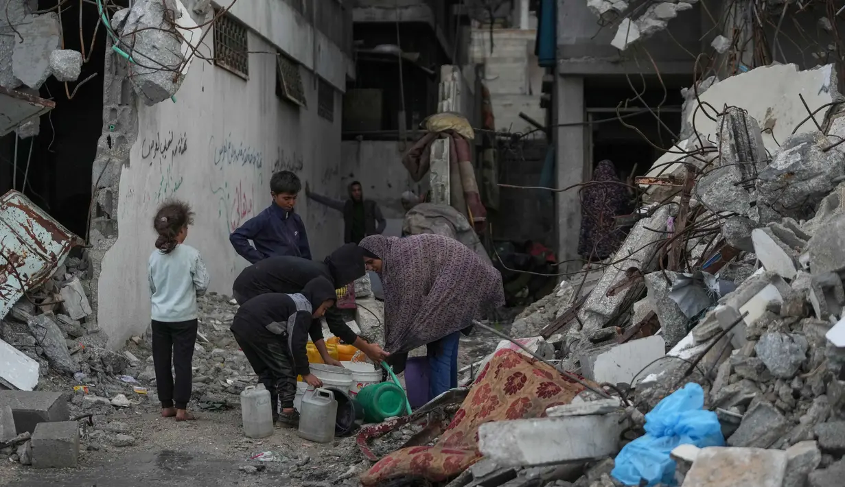 Ribuan orang harus mengantre berjam-jam untuk mendapatkan air dalam jumlah yang sangat sedikit. Tampak dalam foto, warga Palestina mengumpulkan air dari selang selama hujan deras di kawasan Sheikh Radwan, Kota Gaza, Jumat 14 November 2025. (AP Photo/Jehad Alshrafi)