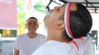 Personel Polsek Lima Puluh mengikuti lomba makan kerupuk menyambut Hari Kemerdekaan Indonesia. (Liputan6.com/M Syukur)