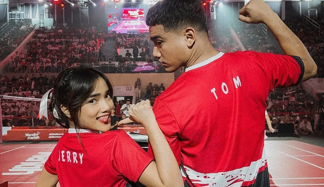 Mengenakan kostum merah-merah dengan bertuliskan Tom dan Jerry. Tokoh serial animasi yang bercerita tentang seekor kucing bernama Tom dan seekor tikus bernama Jerry yang selalu bertengkar. [Instagram/fuji_an]