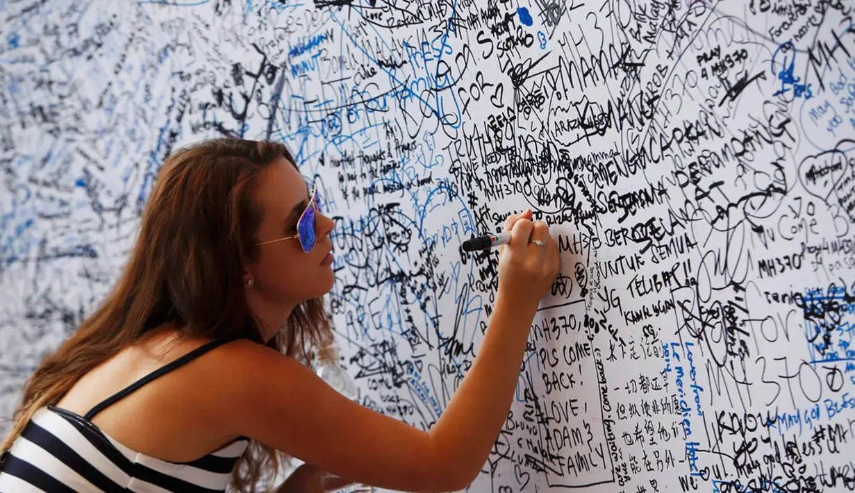 Meski telah penuh dengan tulisan dan tanda tangan, keinginan untuk ikut serta memberikan tulisan empati terus berdatangan (REUTERS/Edgar Su)