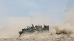 Seorang tentara Jerman menggunakan senapan mesin di atas kendaraan lapis baja saat mereka ikut serta dalam latihan militer bilateral Lituania-Jerman 'Badai Griffin' di Area Pelatihan Jenderal Silvestras Zukauskas di Pabrade, Lituania pada 26 Juni 2023. (AFP/PETRAS MALUKAS)