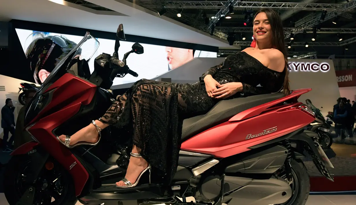 Model berpose diatas motor Kymco Downtown 350i saat pameran Milano Moto Show di Milan, Italia (8/11). Pameran ini menghadirkan kendaraan roda dua keluaran terbaru. (AFP Photo/Miguel Medina)
