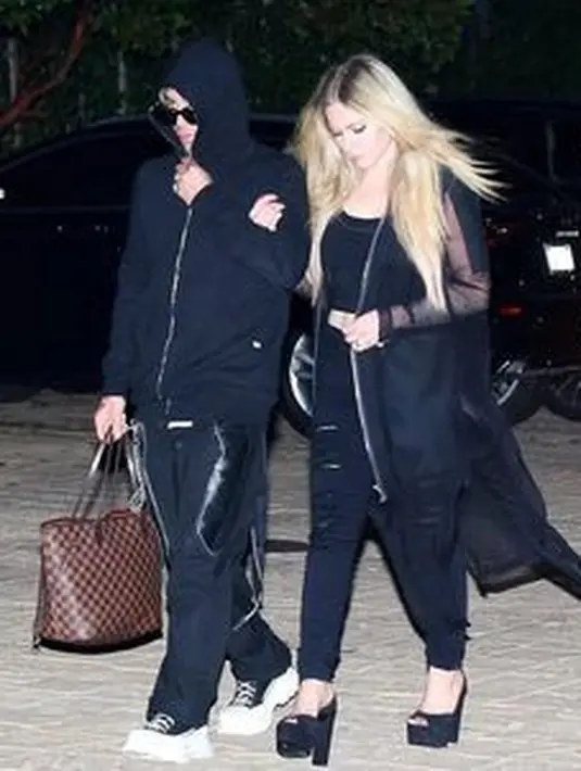 Tetap kece saat dijepret paparazzi dalam outfit serba hitam. Avril memakai peep toe heels dengan outerwear hitam transparan (Foto: Instagram @modsun)