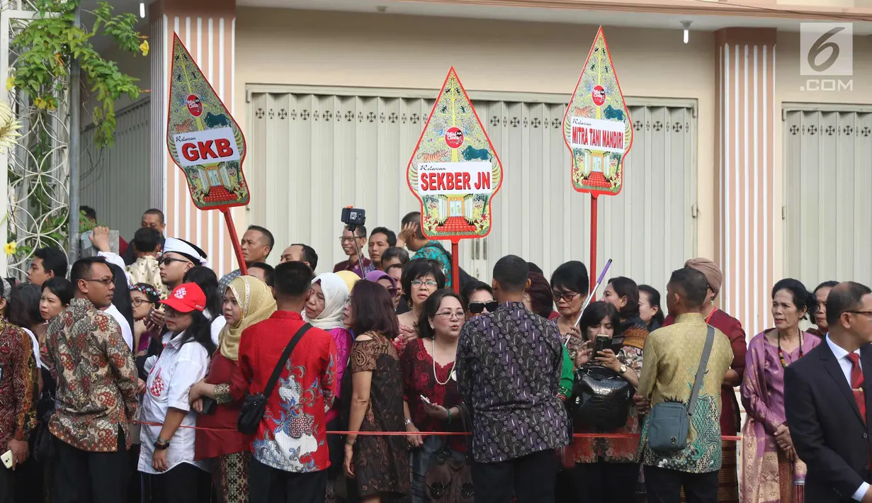 Sejumlah relawan menyaksikan prosesi kirab kereta kencana pernikahan putri Presiden Jokowi,  Kahiyang Ayu-Bobby Nasution saat menuju Gedung Graha Saba di Surakarta, Rabu (8/11). (Liputan6.com/Angga Yuniar)