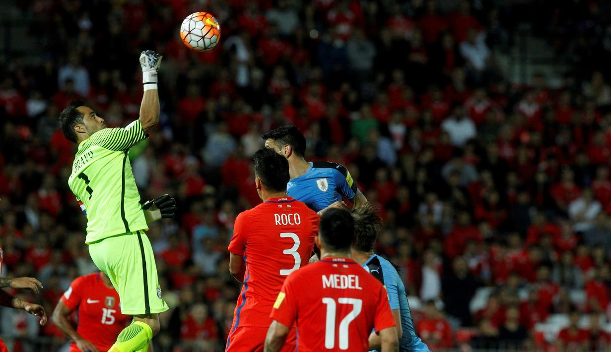 Kiper Cile asal Manchester City, Claudio Bravo, berusaha menghalau bola serangan Uruguay pada laga Kualifikasi Piala Dunia 2018 zona CONMEBOL di Stadion Nasional Julio Martinez Pradanos, Santiago, Rabu (16/11/2016) pagi WIB. (AFP/Claudio Reyes)