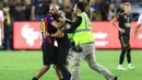 <p>Fans itu berlari ke arah Lionel Messi dan mencoba memeluk LM10. Keinginannya itu batal terwujud setelah Yassine Chueko berlari dan menangkapnya. (Sean M. Haffey/Getty Images/AFP)</p>