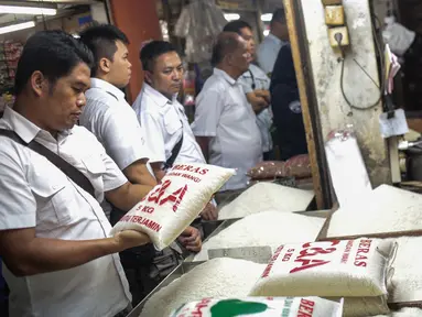 Tim Satgas Pangan Polda Metro Jaya bersama Perum Bulog meninjau harga beras di Pasar Tomang Barat, Jakarta, Rabu (21/11). Kegiatan tersebut bertujuan untuk memantau stabilitas harga beras medium yang dijual di pasaran. (Liputan6.com/Faizal Fanani)