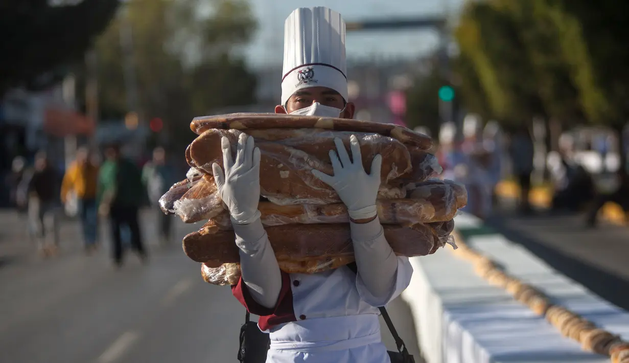 Siswa gastronomi ikut serta memecahkan Guinness World Record dengan membuat kue raja terpanjang di dunia, di Saltillo, Meksiko, 6 Januari 2019. Acara ini juga digelar sebagai pesta tahunan Epiphany di kota tersebut. (Julio Cesar AGUILAR/AFP)
